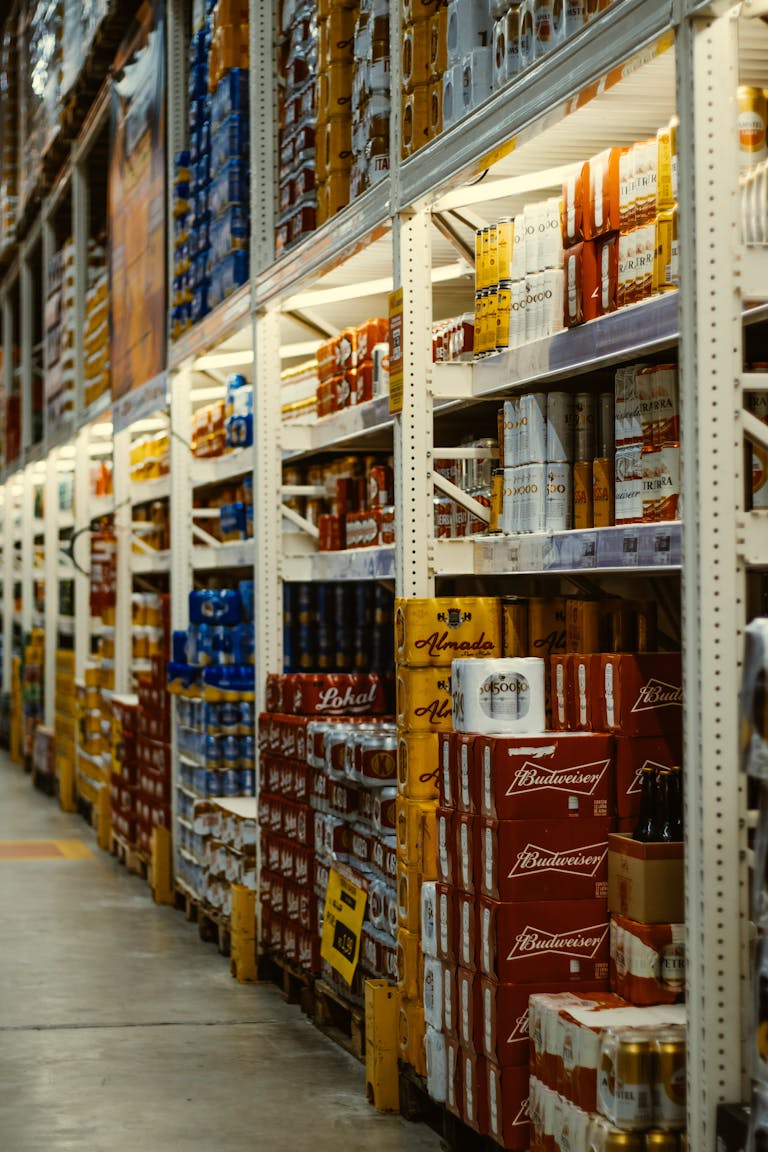 Rows of beer and beverages stacked neatly in a supermarket aisle.