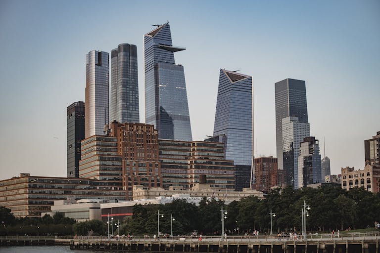 Modern skyscrapers in Hudson Yards, Manhattan against a clear evening sky.